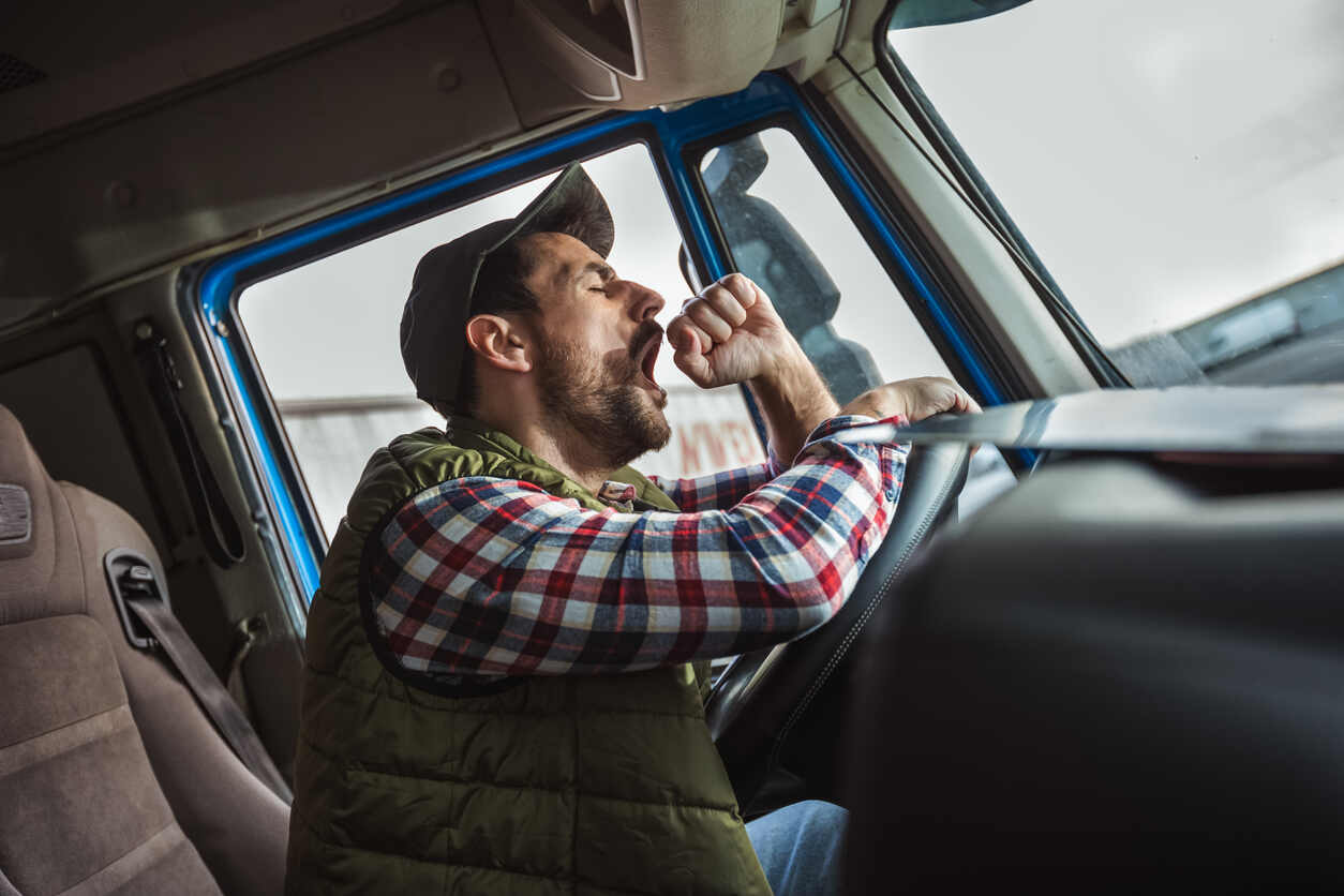 Truck driver is yawning due to fatique