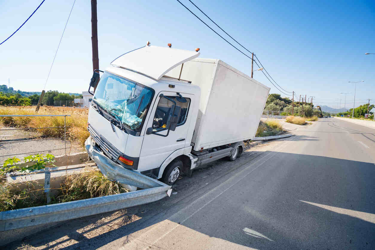 Crashed truck that hit crashed barrier on road.