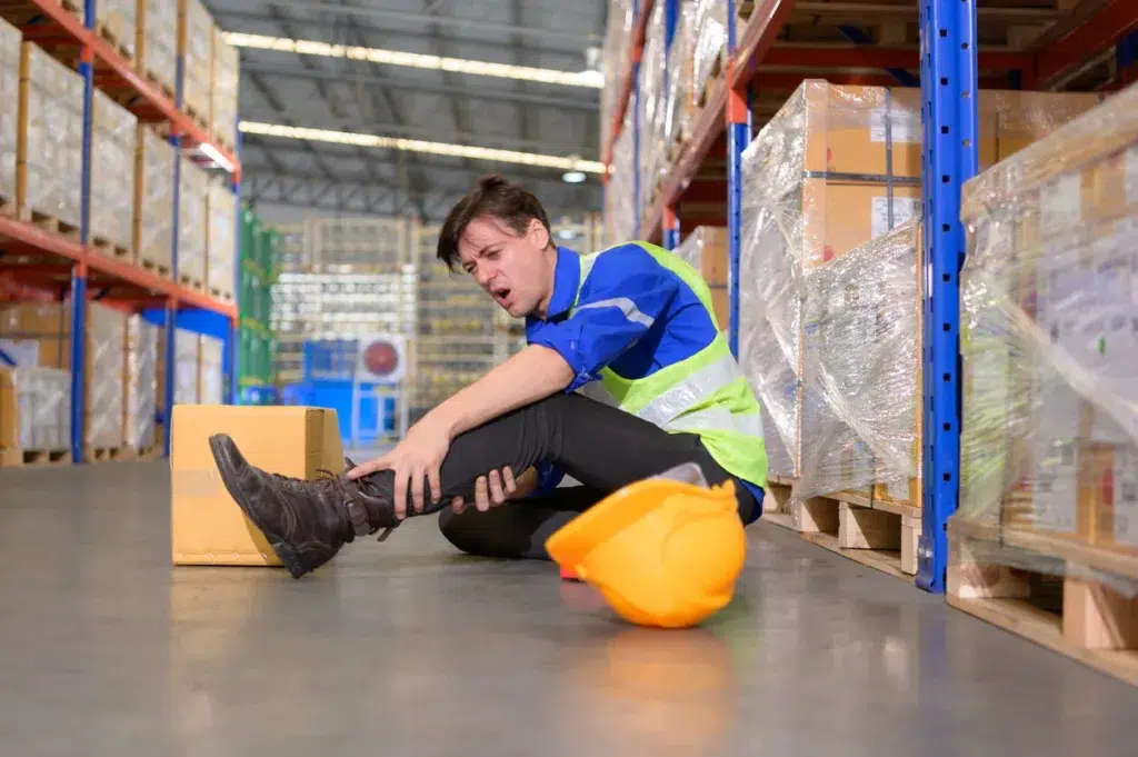 Injured worker in a warehouse due to unsafe layout.