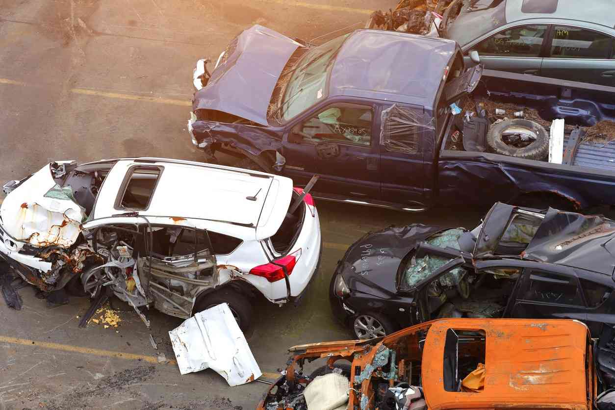 "A scene of multiple crashed cars in a junkyard, representing the complexity of liability in multi-vehicle pileups on Atlanta interstates.