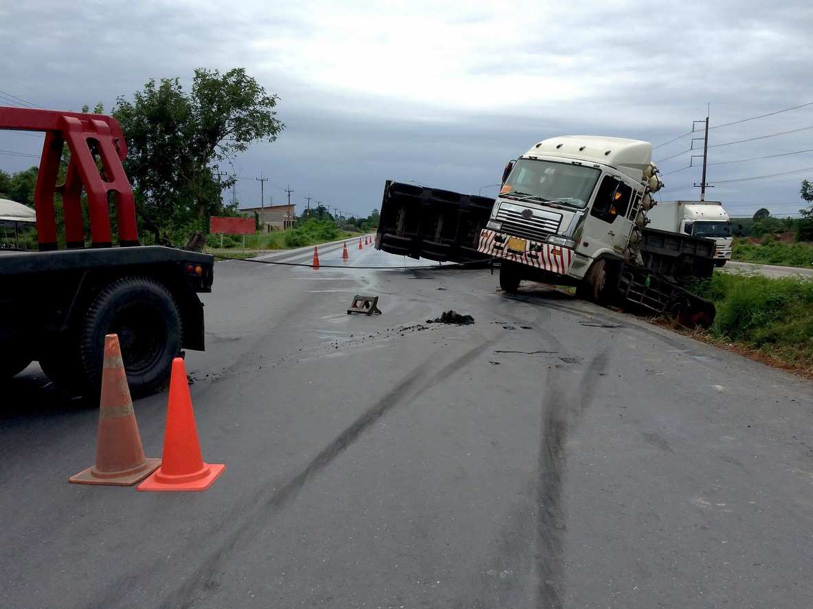 A truck crash scene with emergency cones and a tow truck, symbolizing rapid-response investigations by trucking companies after serious crashes.