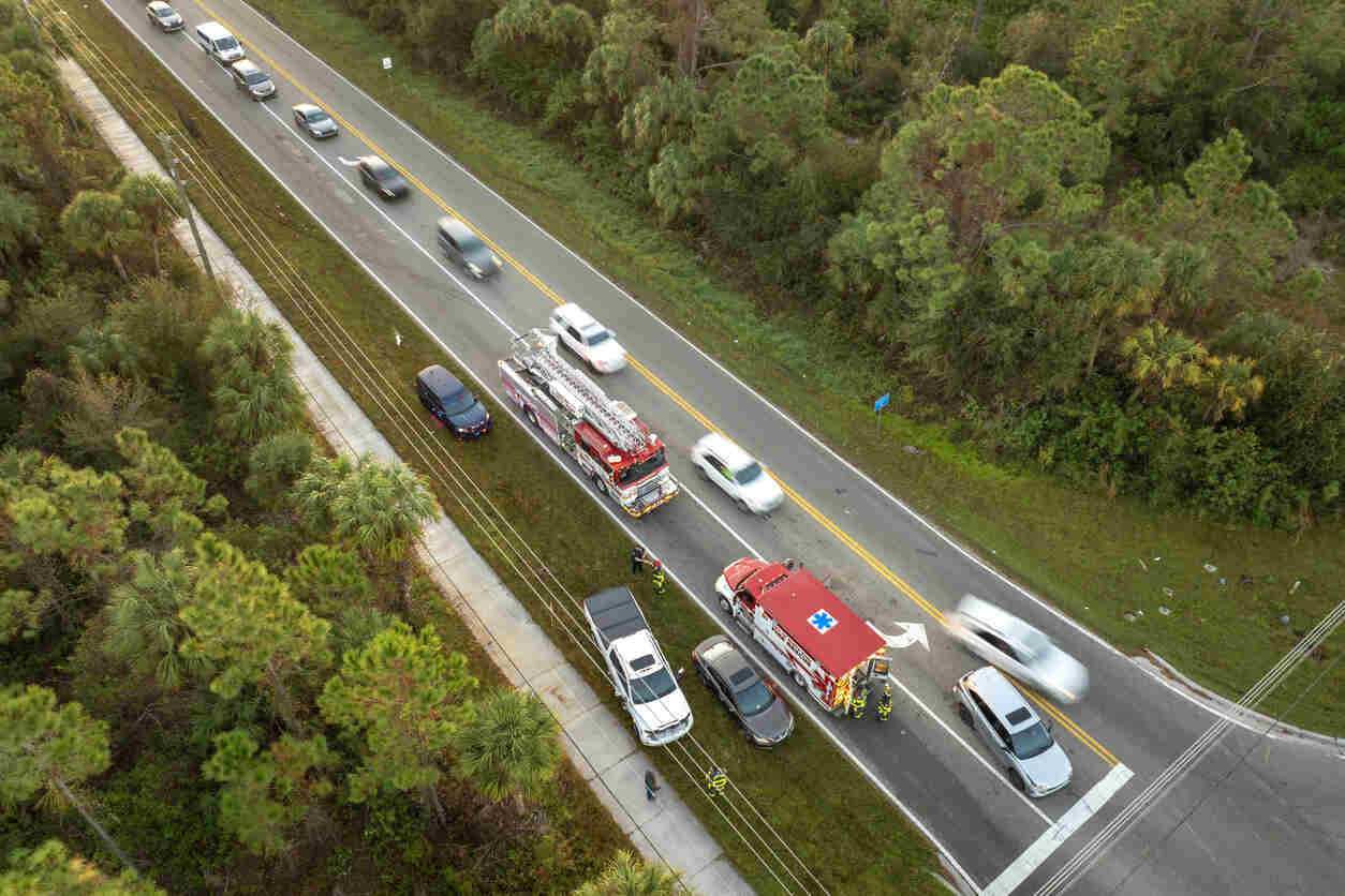 Aerial view of a car accident scene on a Georgia road with emergency responders and vehicles, representing how surveillance footage can impact an injury claim.